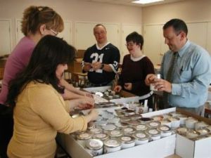 Staff and residents at Pathfinder Village help package a Cooperstown Cookie Company order for the New York Yankees